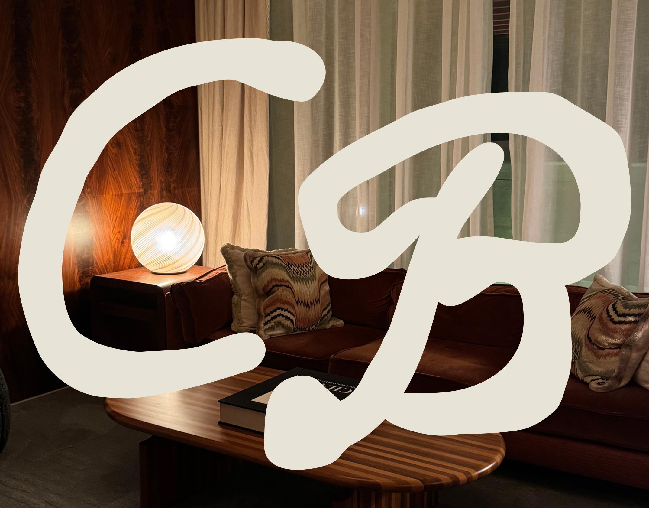 Corner Booth's initials as a brand mark overlaid on a cozy, midcentury interiors background