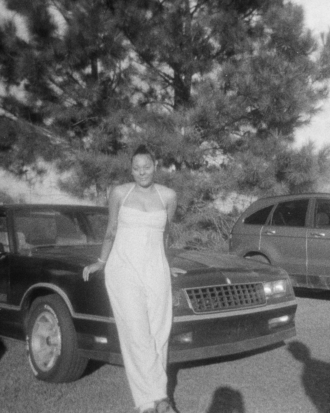 Portrait shot of East Atlanta Clay founder Ashanti leaning against a vintage car