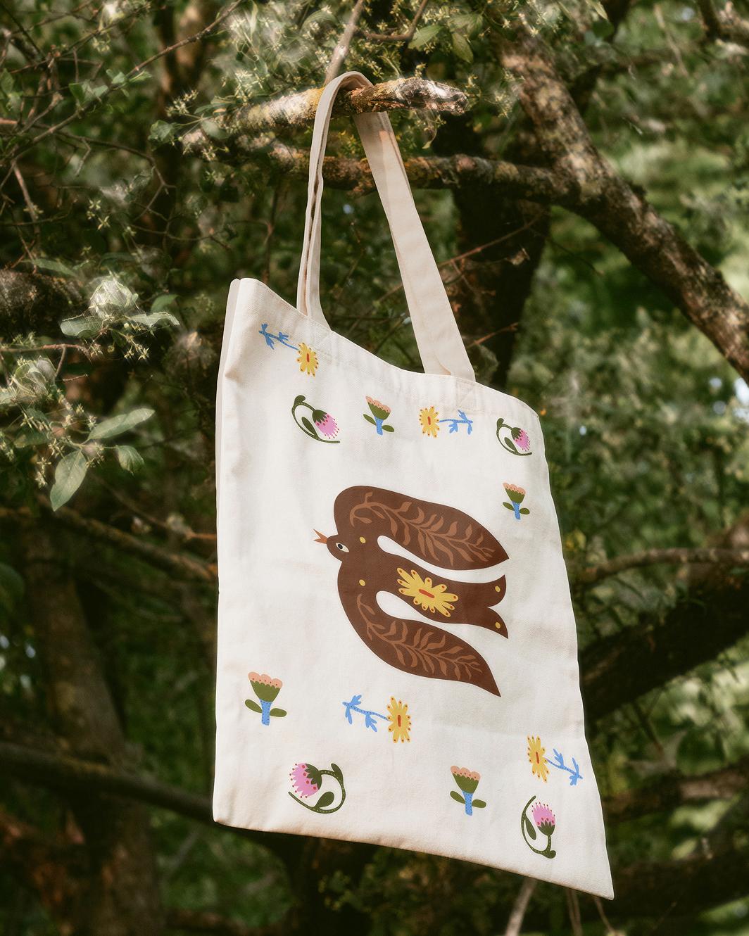 A tote bag hanging off of a tree branch
